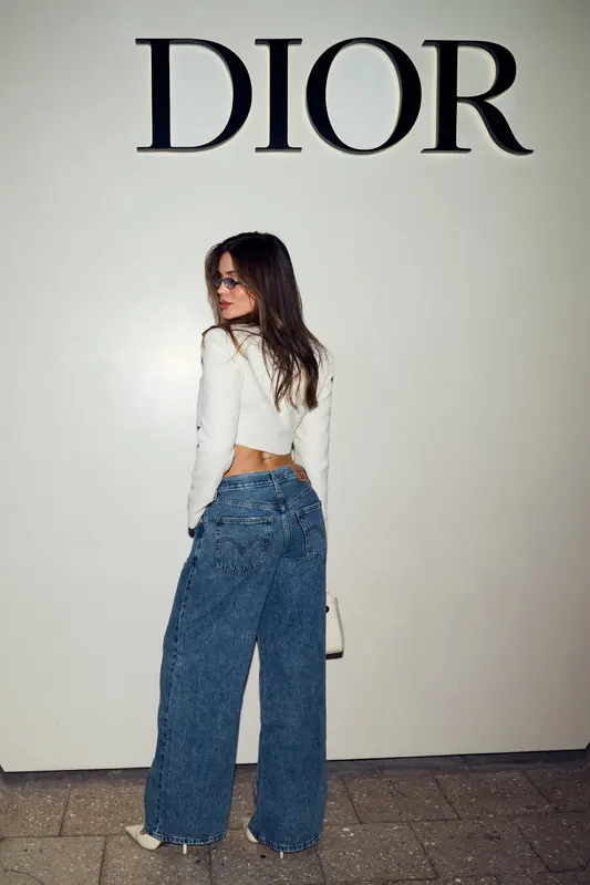 Gabryelle Pedroso wearing a white cropped top and wide-leg denim in a gallery-style setting